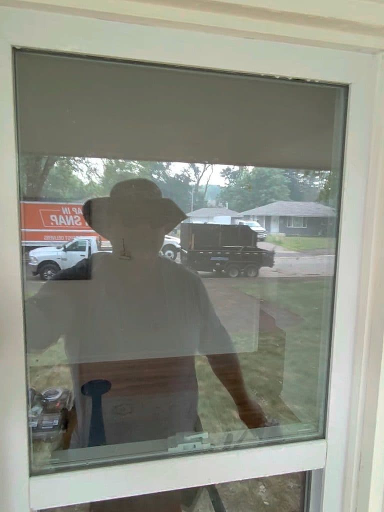 Cleaning the inside of a window with the work truck outside