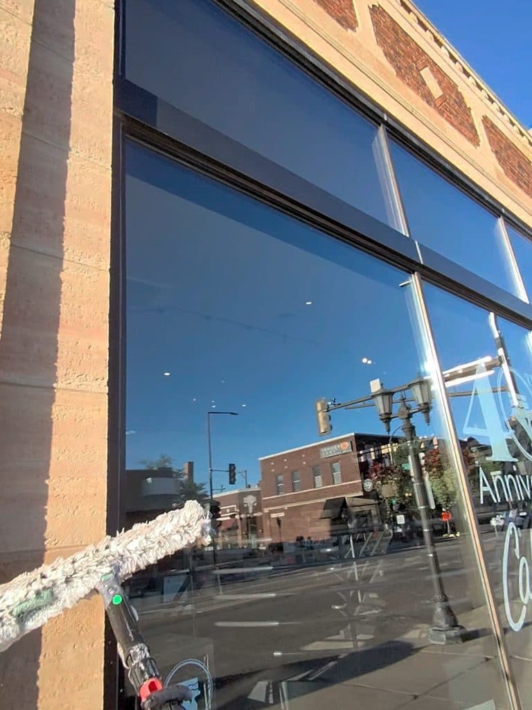 Finished storefront glass reflecting the street