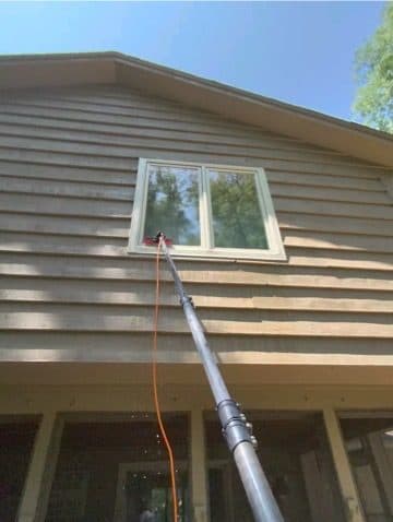 Water-fed pole on an upper window and siding