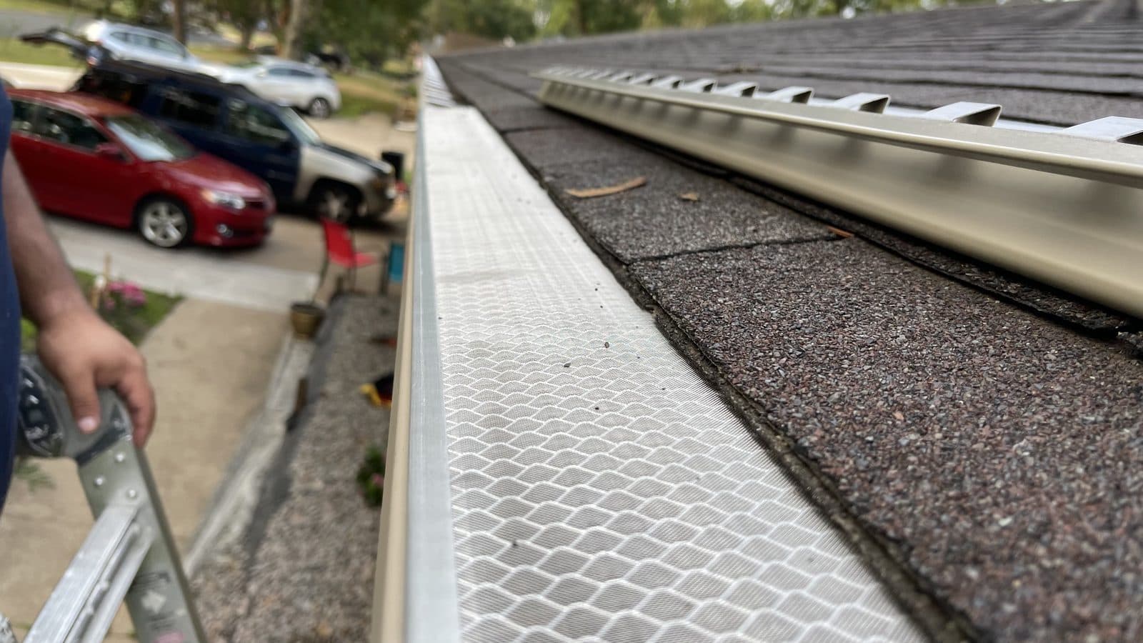 Gutter guard along a roofline, seen from the ladder